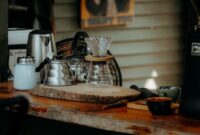 Seorang warga Desa Adat Kemiren menyeduh kopi tradisional menggunakan cangkir tanah liat di tengah suasana pedesaan Banyuwangi yang asri.