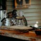 Seorang warga Desa Adat Kemiren menyeduh kopi tradisional menggunakan cangkir tanah liat di tengah suasana pedesaan Banyuwangi yang asri.