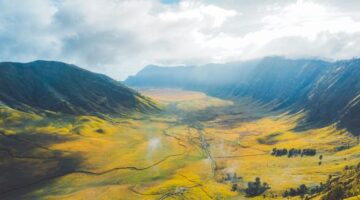 Pemandangan terasering perkebunan warga dan panorama perbukitan hijau di Lembah Sembalun yang terletak tepat di bawah kaki Gunung Rinjani Lombok. Kawasan ini menjadi contoh nyata keberhasilan ekowisata berbasis komunitas yang mampu menjaga kelestarian alam sekaligus meningkatkan taraf hidup masyarakat lokal.