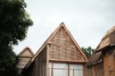 Arsitektur megah hotel yang memadukan ornamen tradisional Nusantara dengan desain modern ramah lingkungan di tengah lanskap hijau.