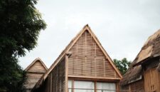 Arsitektur megah hotel yang memadukan ornamen tradisional Nusantara dengan desain modern ramah lingkungan di tengah lanskap hijau.