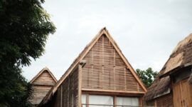 Arsitektur megah hotel yang memadukan ornamen tradisional Nusantara dengan desain modern ramah lingkungan di tengah lanskap hijau.