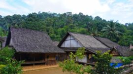 Pemandangan matahari terbit di sebuah desa tradisional perbukitan Indonesia yang menawarkan ketenangan dan keaslian budaya lokal jauh dari hiruk-pikuk kota.