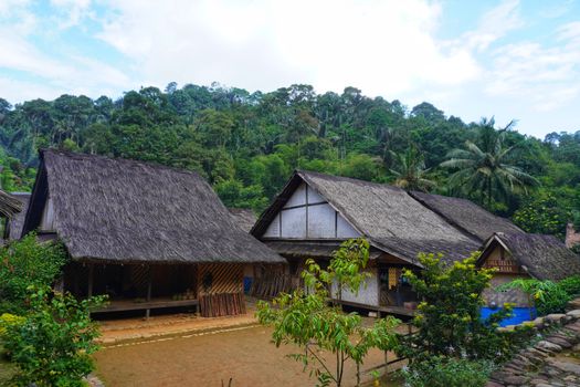 Pemandangan matahari terbit di sebuah desa tradisional perbukitan Indonesia yang menawarkan ketenangan dan keaslian budaya lokal jauh dari hiruk-pikuk kota.