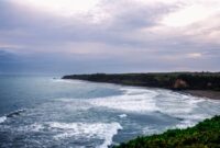 Pemandangan Jalur Lintas Selatan Jawa yang membentang indah di tepi Samudra Hindia, menyuguhkan rute perjalanan darat dengan perpaduan perbukitan hijau dan tebing karang yang mempesona.