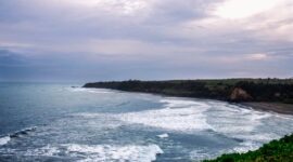 Pemandangan Jalur Lintas Selatan Jawa yang membentang indah di tepi Samudra Hindia, menyuguhkan rute perjalanan darat dengan perpaduan perbukitan hijau dan tebing karang yang mempesona.
