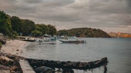 Pemandangan pesisir tenang di Kepulauan Banda yang menawarkan keindahan laut jernih serta deretan bangunan bersejarah di tepi pantai.