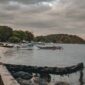 Pemandangan pesisir tenang di Kepulauan Banda yang menawarkan keindahan laut jernih serta deretan bangunan bersejarah di tepi pantai.