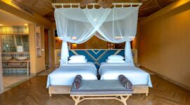 Desain interior megah Hotel Nusantara yang menggabungkan ukiran kayu tradisional dengan lanskap hijau hutan tropis di kawasan Ibu Kota Nusantara.