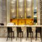 Suasana lobi Hotel Nusantara di Penajam Paser Utara yang memadukan keindahan elemen arsitektur kayu tradisional Dayak dengan fasilitas kemewahan modern. Pemandangan hutan tropis Kalimantan terlihat jelas melalui jendela kaca besar yang memberikan pencahayaan alami sepanjang hari.