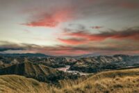 Pemandangan bukit sabana Wairinding di Sumba Timur saat matahari terbit, menampilkan keindahan panorama lanskap yang tenang dan alami jauh dari pemukiman padat.