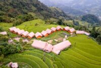 Suasana sebuah penginapan ramah lingkungan di kawasan pedesaan Indonesia yang menawarkan ketenangan alam dan interaksi hangat dengan kearifan lokal.