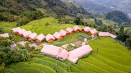 Suasana sebuah penginapan ramah lingkungan di kawasan pedesaan Indonesia yang menawarkan ketenangan alam dan interaksi hangat dengan kearifan lokal.