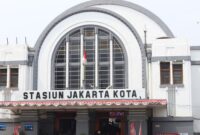 Para wisatawan menikmati keindahan pemandangan pegunungan dan sawah hijau dari dalam kereta wisata bereksterior kaca panorama yang nyaman.