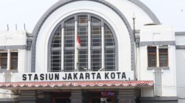 Para wisatawan menikmati keindahan pemandangan pegunungan dan sawah hijau dari dalam kereta wisata bereksterior kaca panorama yang nyaman.