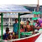 Sebuah perahu kayu penyeberangan melaju membelah perairan jernih di kepulauan Nusantara untuk mengantarkan para pelancong menjelajahi destinasi tersembunyi.