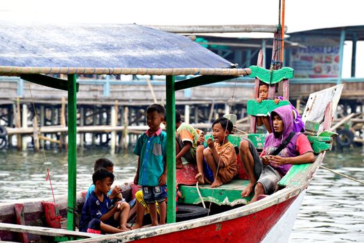 Sebuah perahu kayu penyeberangan melaju membelah perairan jernih di kepulauan Nusantara untuk mengantarkan para pelancong menjelajahi destinasi tersembunyi.
