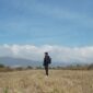 Seorang pelancong yang membawa tas punggung ringkas berjalan santai di area terminal keberangkatan bandara tanpa terbebani oleh koper berukuran besar.