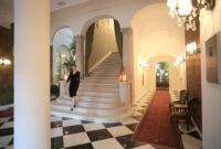 Suasana koridor berarsitektur Art Deco di Hotel Majapahit Surabaya yang masih mempertahankan keaslian lantai marmer dan furnitur kayu jati sejak era kolonial.