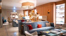 Suasana lobi hotel mewah klasik bernuansa abad ke-19 yang menggambarkan keanggunan era awal berdirinya penginapan modern bagi para pengelana kelas atas.