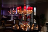Suasana lobi hotel modern berdesain elegan yang memadukan pencahayaan hangat dan unsur estetika kontemporer sebagai pusat aktivitas para tamu.