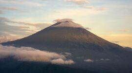 Pemandangan megah Gunung Api Banda yang menjulang di balik perairan jernih Banda Neira, Maluku Tengah, menjadi salah satu latar alam paling memukau bagi para pelancong.