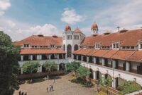 Suasana lobi bergaya arsitektur klasik pada bangunan hotel bersejarah yang memadukan keanggunan era kolonial dengan sentuhan elemen kebudayaan Nusantara.