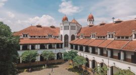 Suasana lobi bergaya arsitektur klasik pada bangunan hotel bersejarah yang memadukan keanggunan era kolonial dengan sentuhan elemen kebudayaan Nusantara.