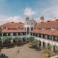 Suasana lobi bergaya arsitektur klasik pada bangunan hotel bersejarah yang memadukan keanggunan era kolonial dengan sentuhan elemen kebudayaan Nusantara.