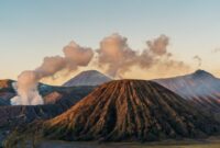 Pemandangan pagi hari di pemukiman lereng Bromo yang menyajikan suasana tenang dan hamparan ladang hijau warga lokal.