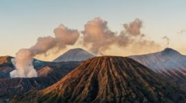 Pemandangan pagi hari di pemukiman lereng Bromo yang menyajikan suasana tenang dan hamparan ladang hijau warga lokal.