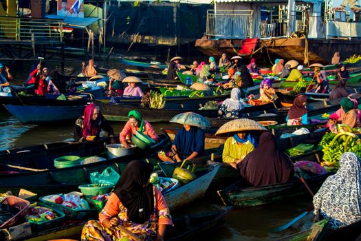 Seorang pelancong menikmati suasana tenang pedesaan di Flores sembari berinteraksi dengan warga lokal yang sedang mengolah kain tenun tradisional.