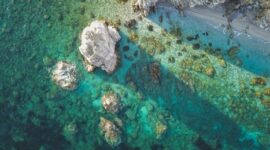 Pemandangan perairan jernih di Kepulauan Alor yang menjaga kelestarian terumbu karang dan mamalia laut melalui kearifan lokal masyarakat pesisir.