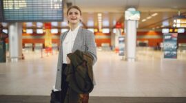 Seorang pelancong tampak memeriksa kelengkapan dokumen perjalanan dan paspor dengan tenang di terminal keberangkatan bandara sebelum memulai petualangannya.