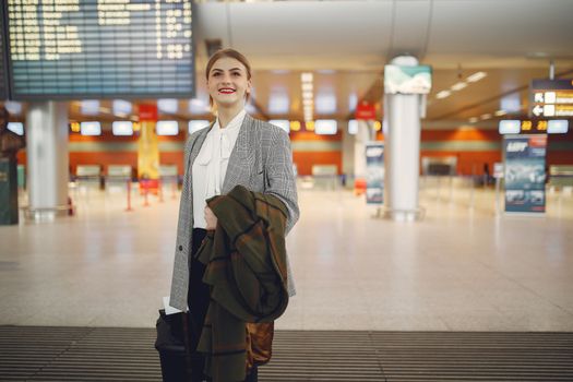 Seorang pelancong tampak memeriksa kelengkapan dokumen perjalanan dan paspor dengan tenang di terminal keberangkatan bandara sebelum memulai petualangannya.