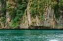 Pemandangan tebing granit megah yang mengapit hamparan sawah hijau di Lembah Harau, Sumatra Barat, memberikan suasana tenang yang ideal untuk perjalanan perlahan.
