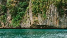 Pemandangan tebing granit megah yang mengapit hamparan sawah hijau di Lembah Harau, Sumatra Barat, memberikan suasana tenang yang ideal untuk perjalanan perlahan.