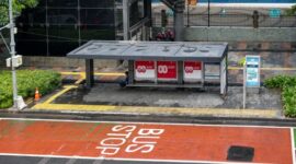 Seorang wisatawan menikmati pemandangan pesisir dari atas moda transportasi umum yang terhubung langsung dengan rute penyeberangan antarpulau di Indonesia.