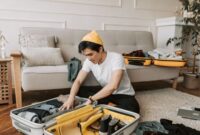 Seorang pelancong menyusun barang bawaannya secara rapi dan efisien dalam koper berukuran sedang sebelum memulai perjalanan. Teknik pengemasan yang ringkas membantu menjaga kenyamanan dan kelancaran selama berlibur.