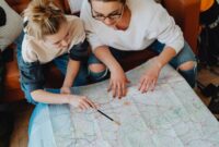 Seorang pelancong sedang mengamati peta rute perjalanan untuk menyusun rencana liburan yang efisien dan bermakna.