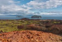 Pemandangan megah Gunung Api Banda yang menjulang tinggi di seberang perairan jernih Kepulauan Banda Neira saat pagi hari.