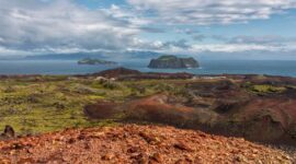 Pemandangan megah Gunung Api Banda yang menjulang tinggi di seberang perairan jernih Kepulauan Banda Neira saat pagi hari.