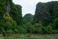 Dua wisatawan menikmati pemandangan lanskap tebing granit hijau dan hamparan sawah di Lembah Harau, Kabupaten Lima Puluh Kota, Sumatera Barat.