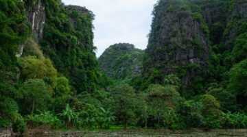 Dua wisatawan menikmati pemandangan lanskap tebing granit hijau dan hamparan sawah di Lembah Harau, Kabupaten Lima Puluh Kota, Sumatera Barat.