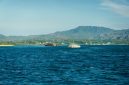 Sebuah kapal cepat penumpang melintasi perairan jernih kepulauan Indonesia untuk mengantarkan wisatawan ke destinasi terpencil dengan aman dan nyaman.