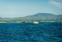 Sebuah kapal cepat penumpang melintasi perairan jernih kepulauan Indonesia untuk mengantarkan wisatawan ke destinasi terpencil dengan aman dan nyaman.