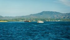 Sebuah kapal cepat penumpang melintasi perairan jernih kepulauan Indonesia untuk mengantarkan wisatawan ke destinasi terpencil dengan aman dan nyaman.